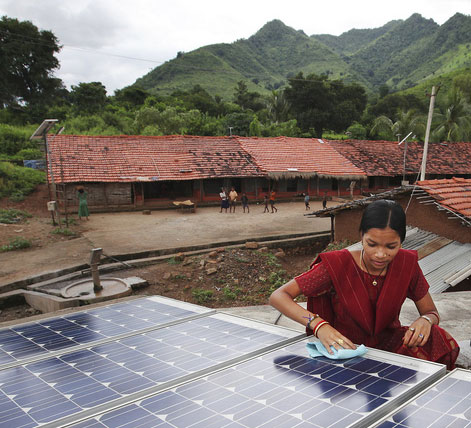 Photo: woman wiping a solar panel